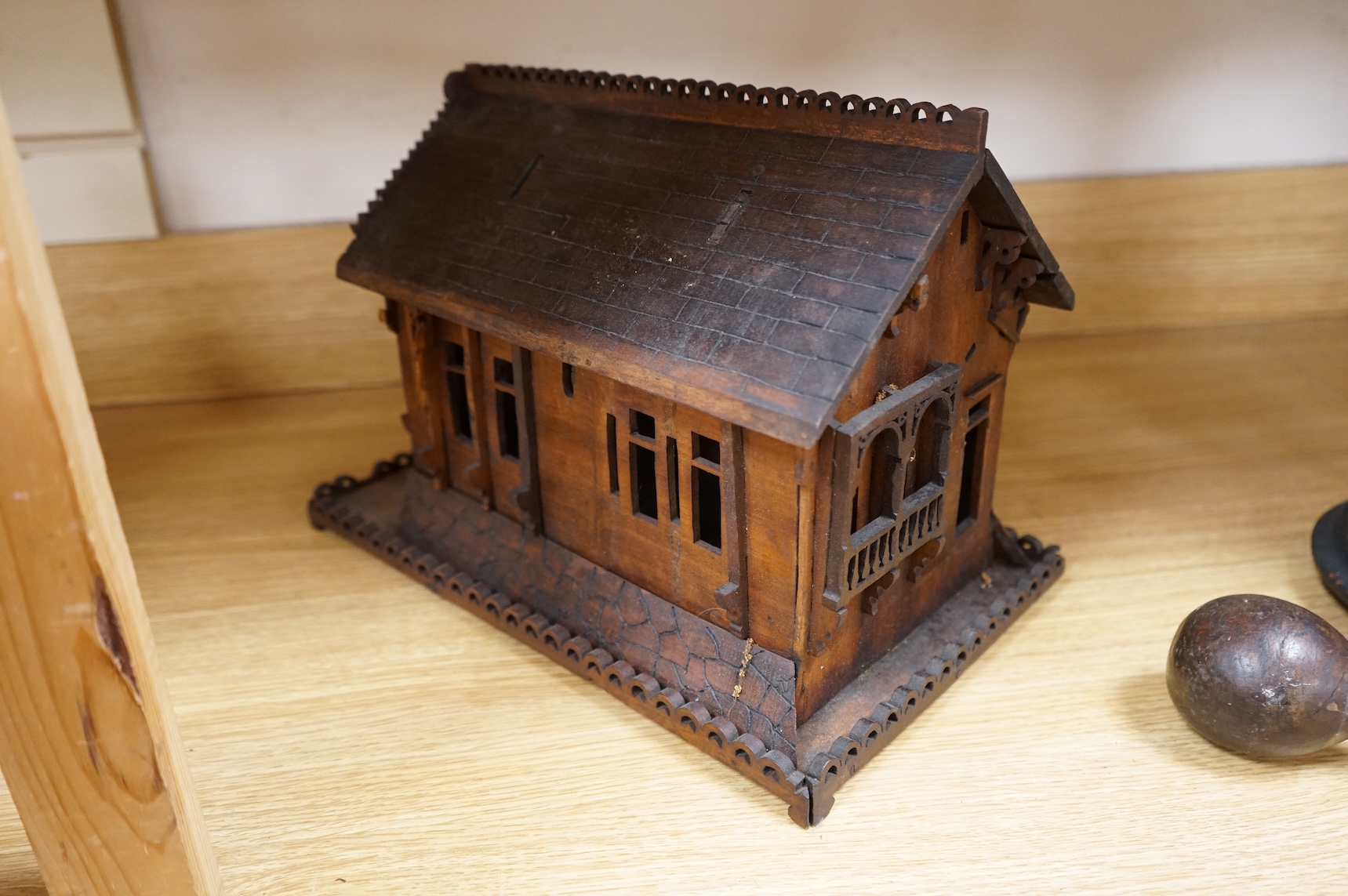 An early 20th century Black Forest carved walnut musical footed dish together with a model of a house (2)